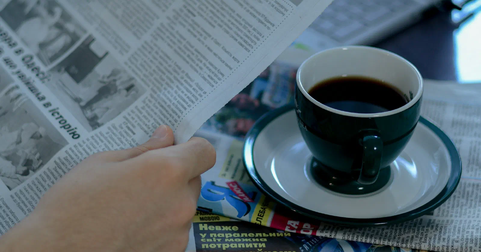 A man reading the morning news over a cup of coffee